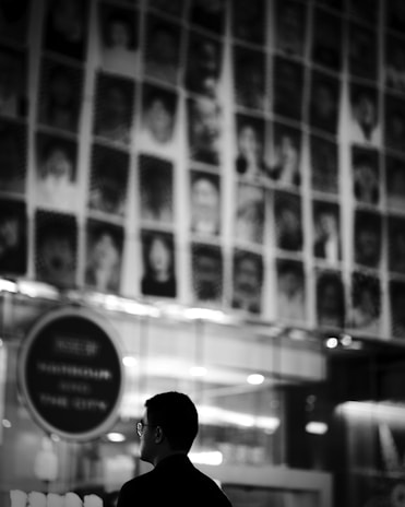 A close-up shot of textured black-and-white portrait photography hanging on a minimalist gallery wall.