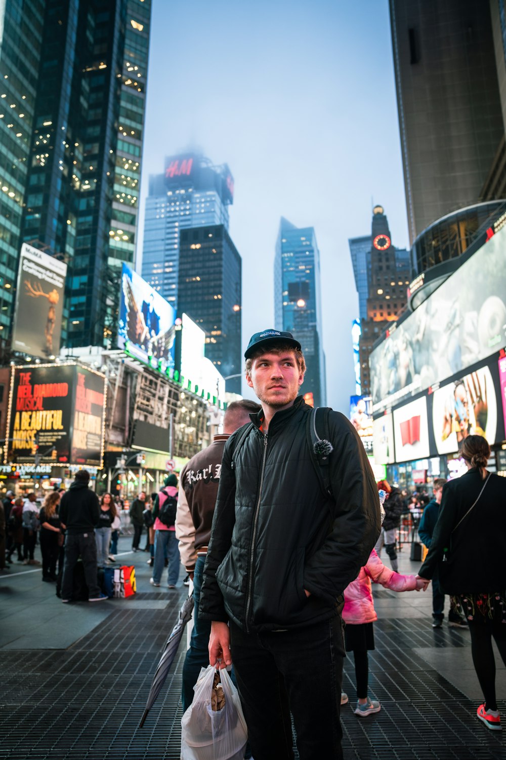 a man standing in the middle of a busy city street