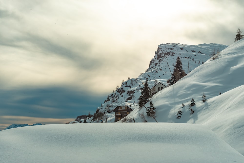 a snow covered mountain with a house in the distance