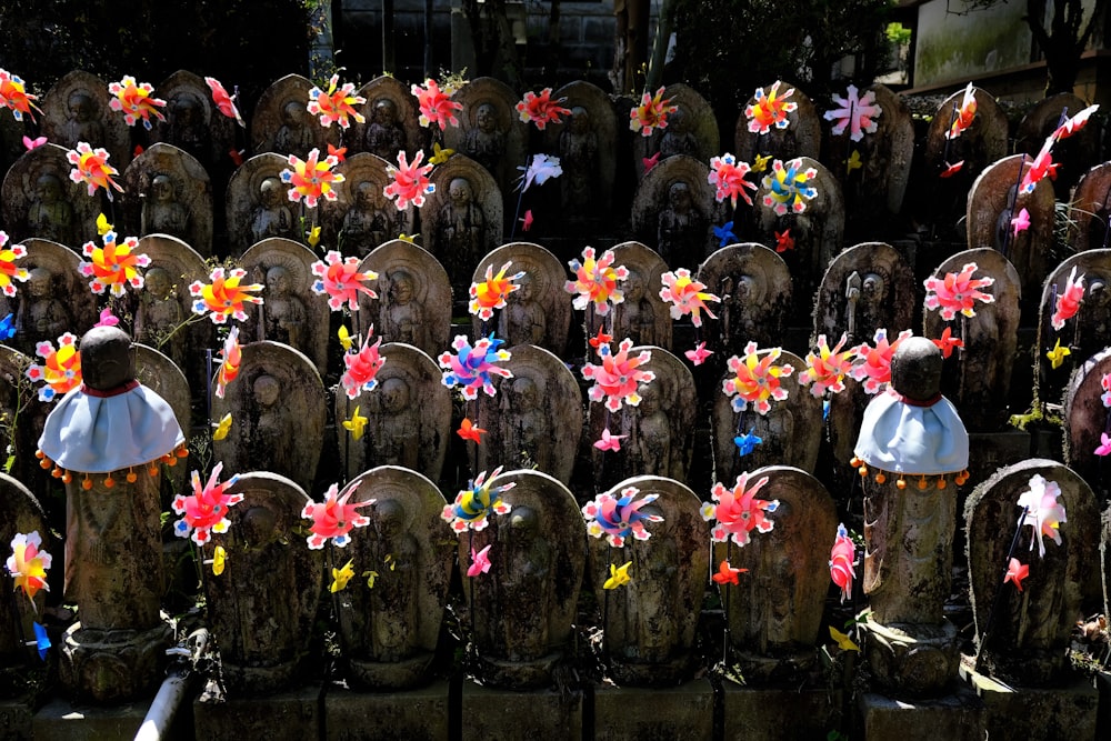 a bunch of wooden statues with flowers on them