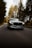 a silver car driving down a road with trees in the background