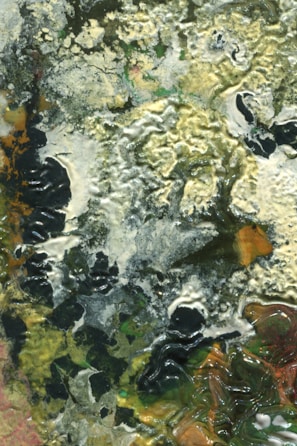 Close-up of a textured abstract painting with warm earth tones.