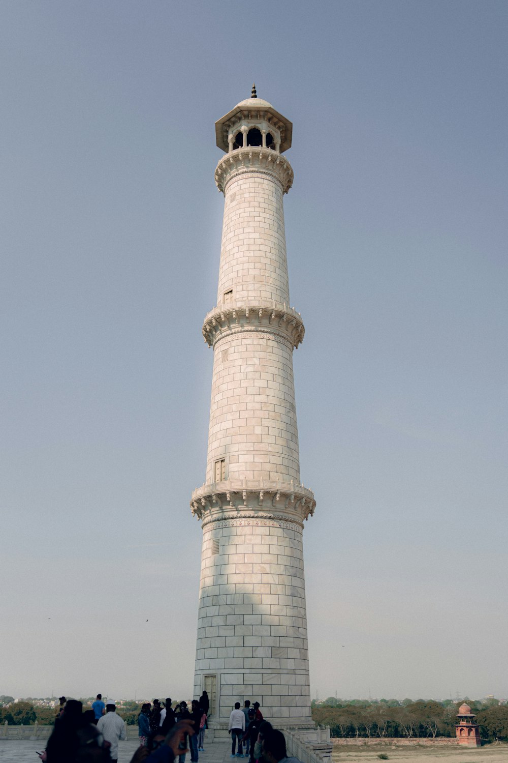 a group of people standing in front of a lighthouse