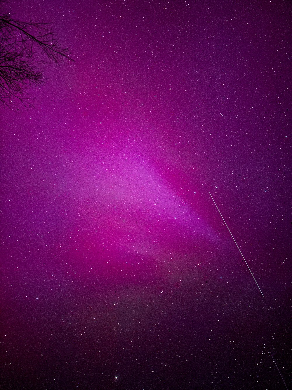 a purple sky with stars and a plane in the distance
