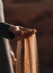 a person holding sand in their hands