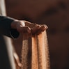 a person holding sand in their hands