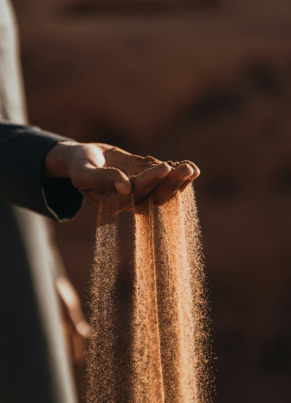 a person holding sand in their hands