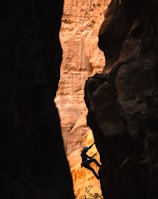 a man climbing up the side of a cliff