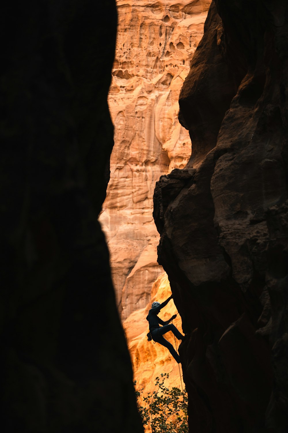 un uomo che si arrampica sul fianco di una scogliera