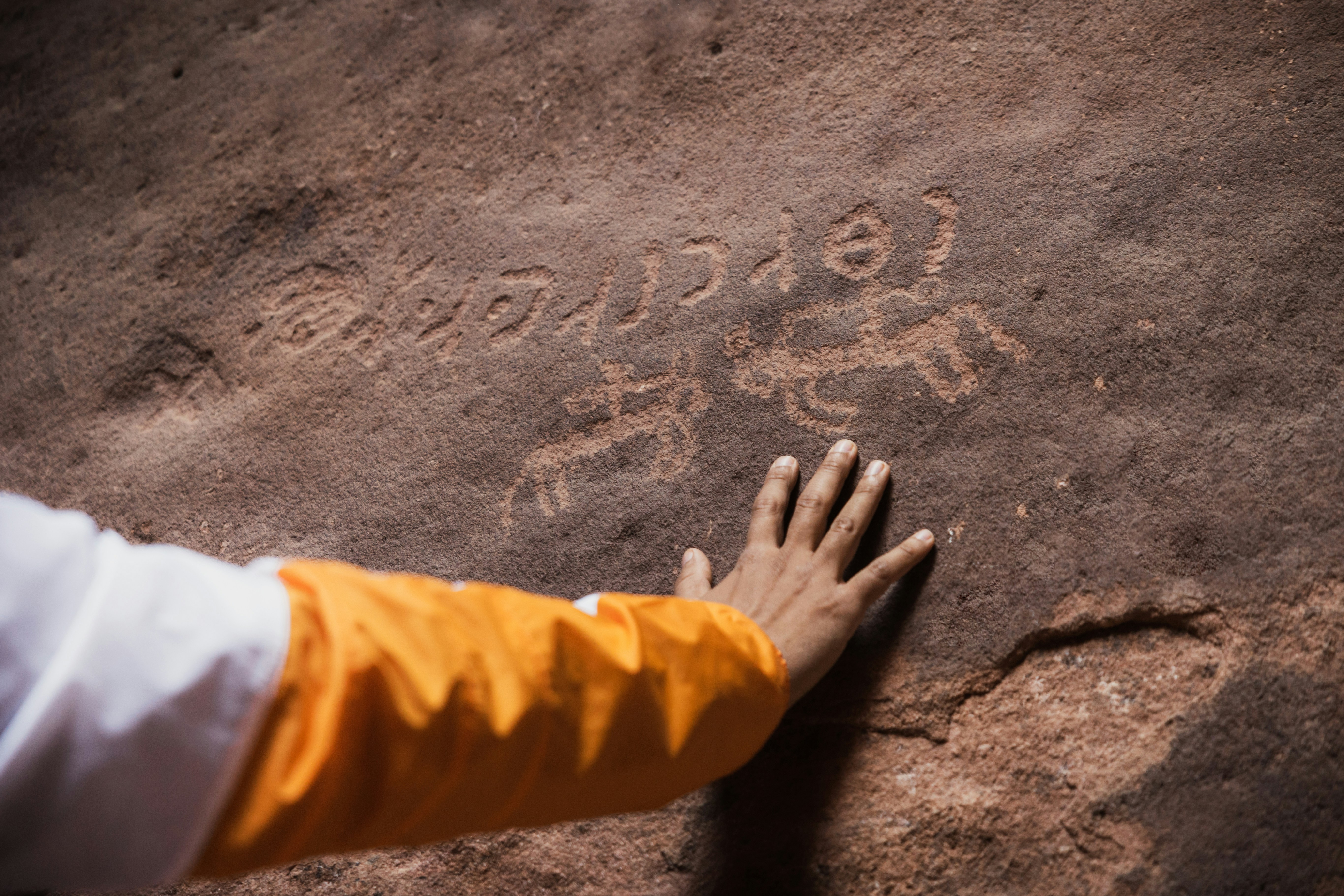 a person with their hand on a rock