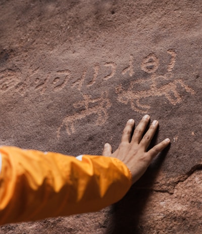 a person with their hand on a rock