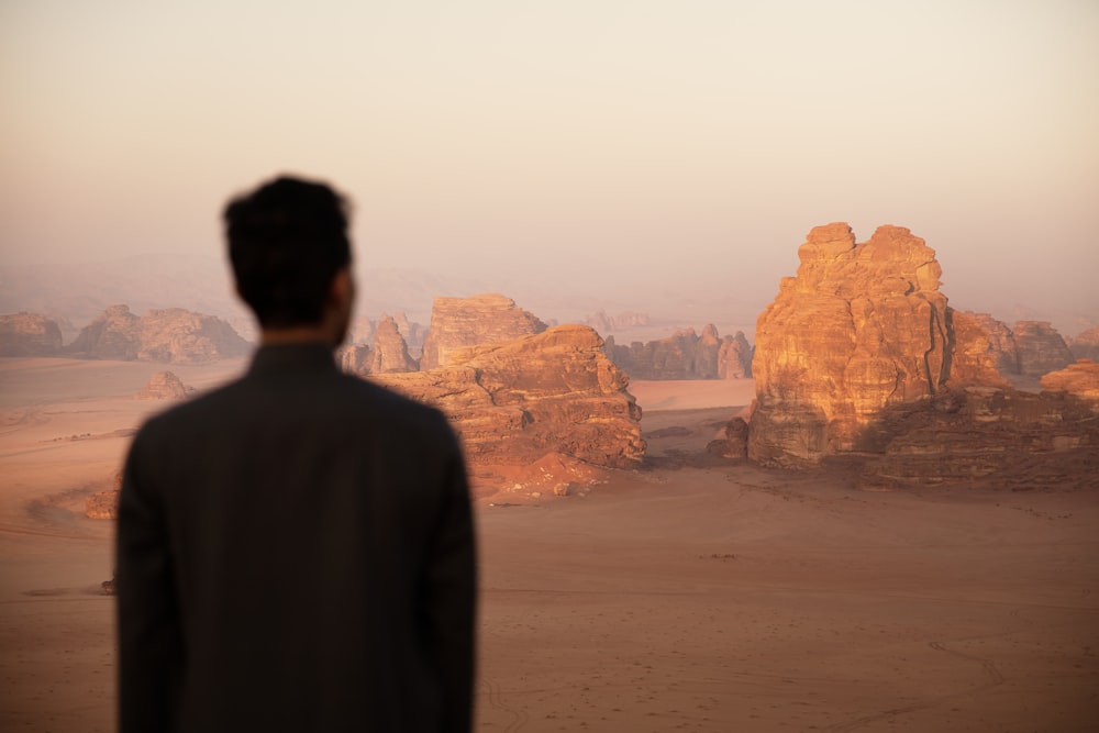 a man standing in front of a desert landscape