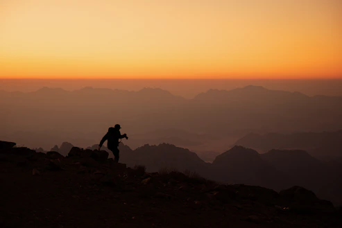 a person standing on top of a mountain at sunset