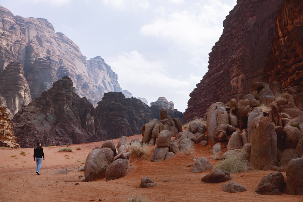 a person walking through a desert area with large rocks