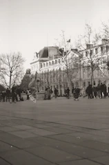 A monochrome photo of a skateboarder wearing noirvibe apparel against a gritty city backdrop.