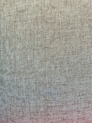A close-up view of a textured fabric with a woven pattern. The fabric appears to be coarse with visible individual threads creating a consistent, grid-like design.