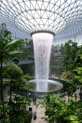 a large waterfall in the middle of a tropical garden