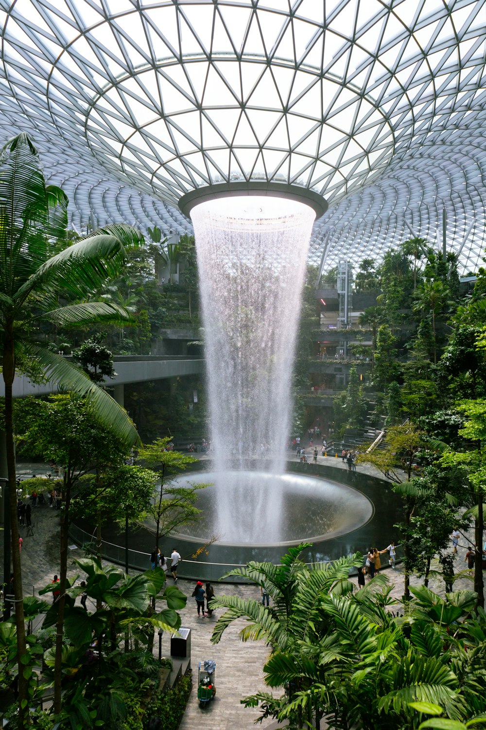 a large waterfall in the middle of a tropical garden