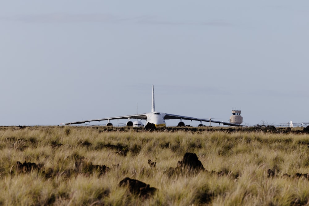 a large jetliner sitting on top of a dry grass field