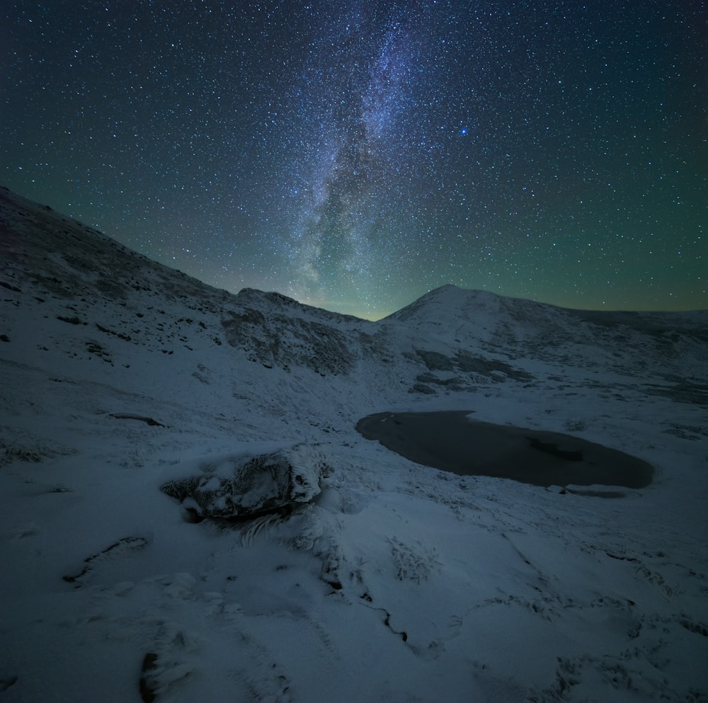 Le ciel nocturne avec des étoiles au-dessus d’une montagne enneigée