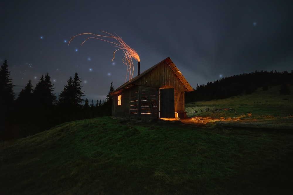 a small cabin on a hill at night