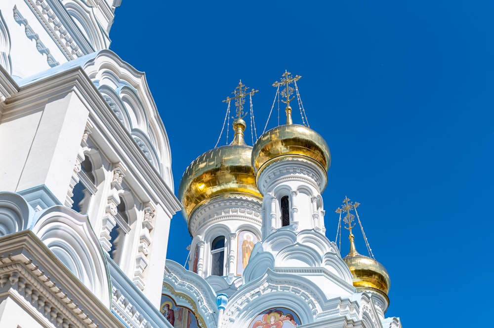 a large white and gold building with a clock on it's side