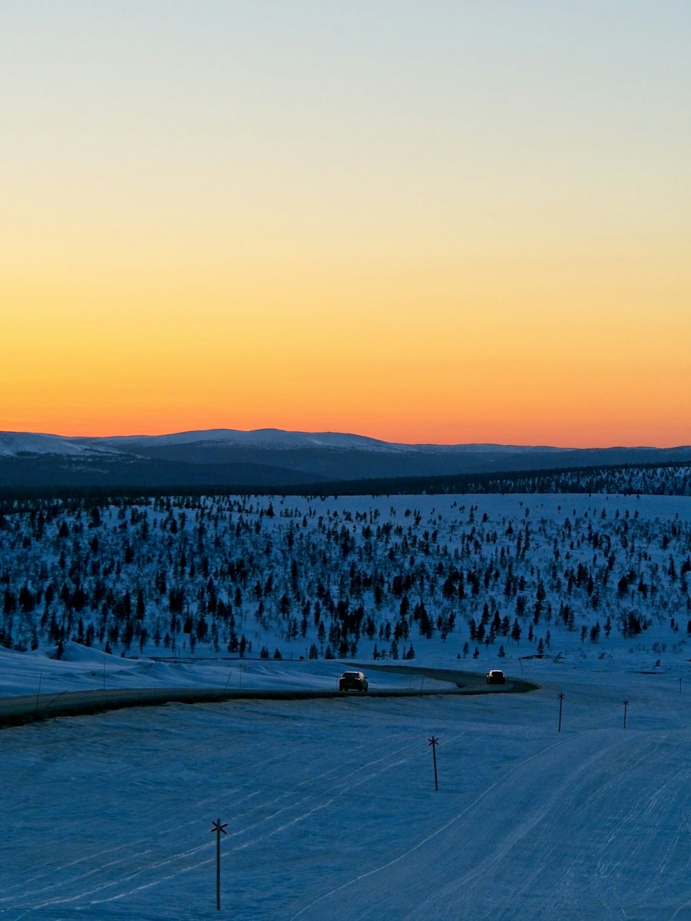 the sun is setting over a snowy landscape