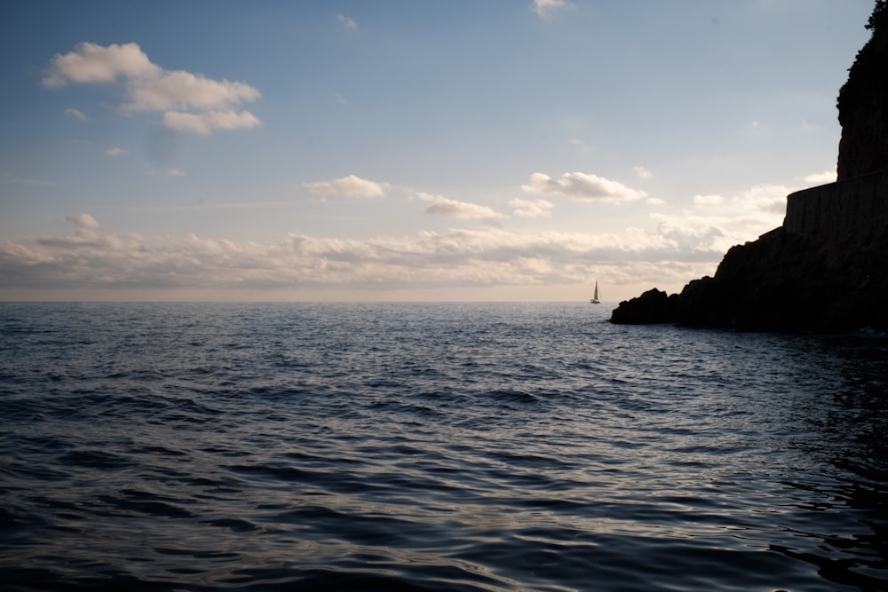 a large body of water with a lighthouse in the distance