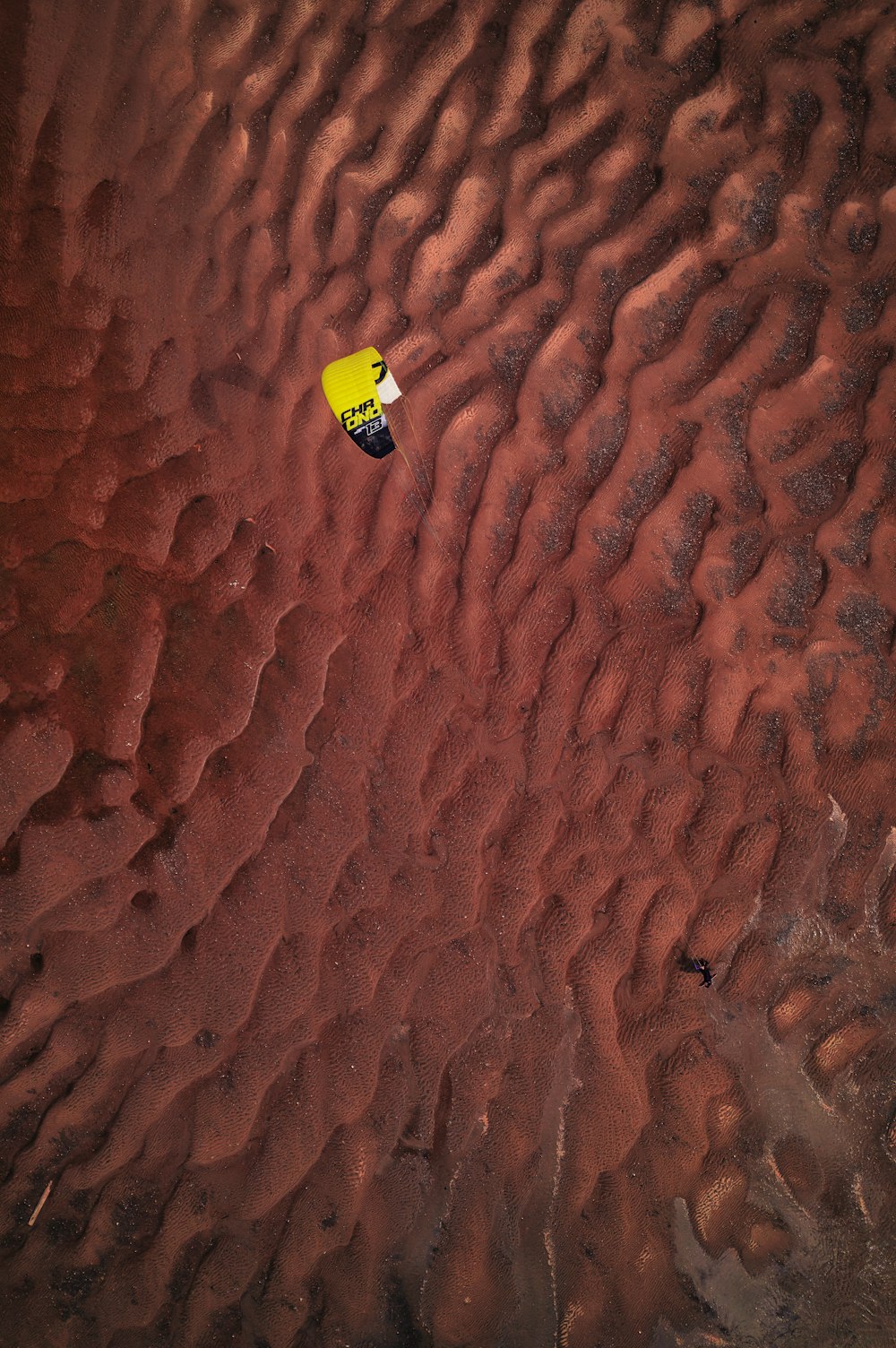 a yellow object floating on top of a sandy beach