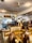 An antique shop filled with vintage furniture and decor. Leather sofas and ornate wooden tables dominate the space. The ceiling hosts a series of small pendant lights. The room is accessorized with different decorative items, including mirrors, artwork, and sculptures.