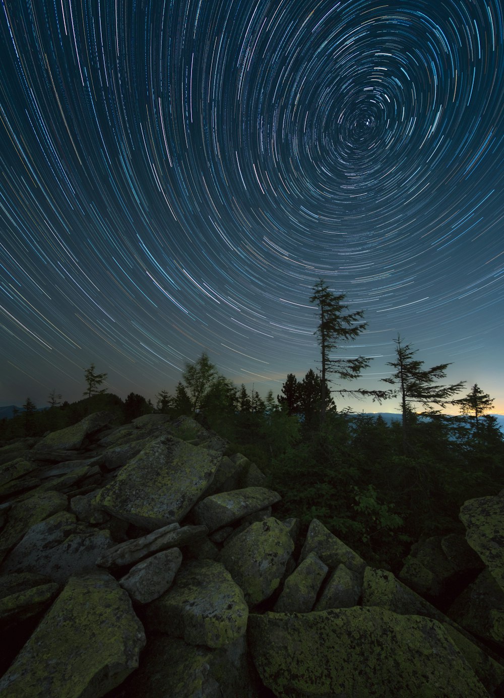 the night sky with a star trail in the background