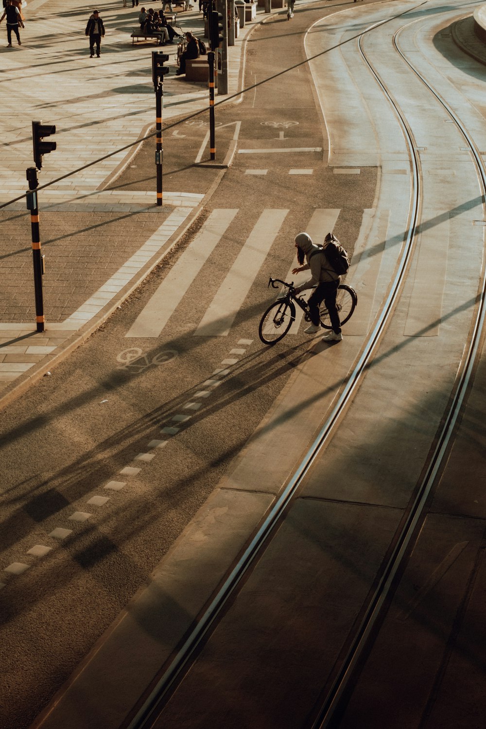 a man riding a bike down a street next to a traffic light