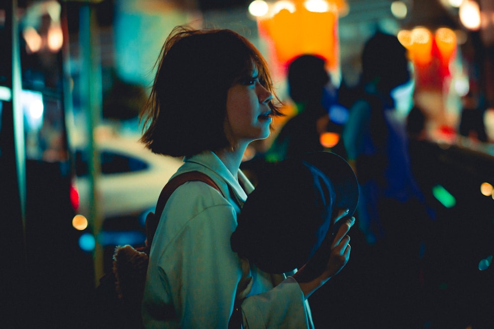 a woman standing on a street at night