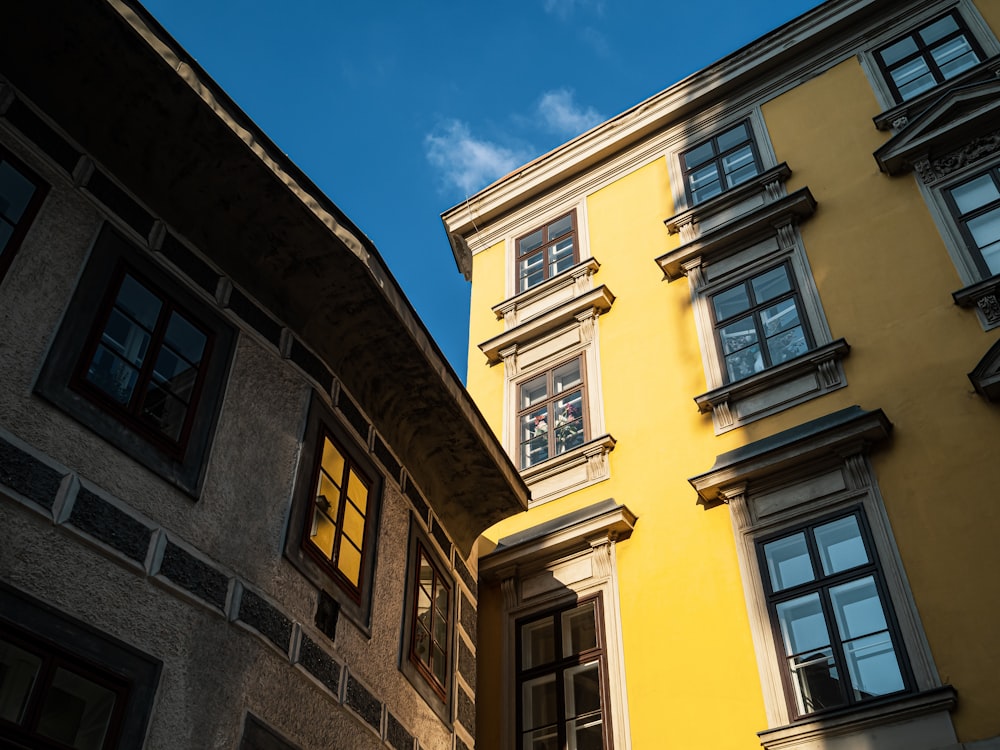 Un alto edificio amarillo sentado al lado de un alto edificio amarillo