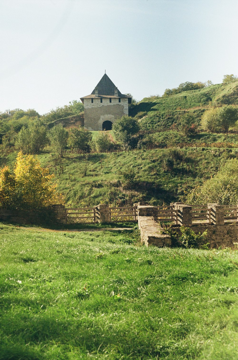 a house on a hill with a fence in front of it