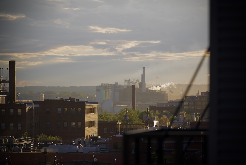 a view of a city with smoke stacks in the distance