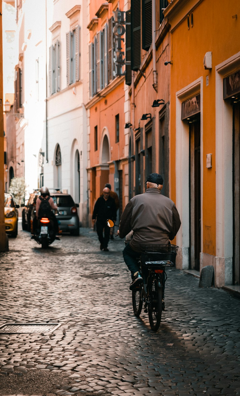 a man riding a bike down a cobblestone street