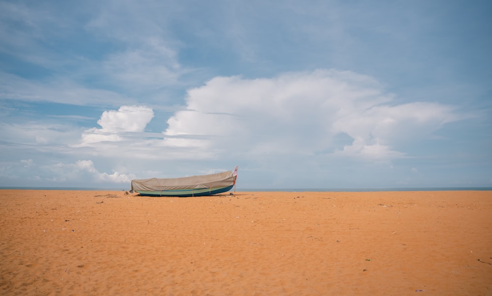 a boat sitting on top of a sandy beach