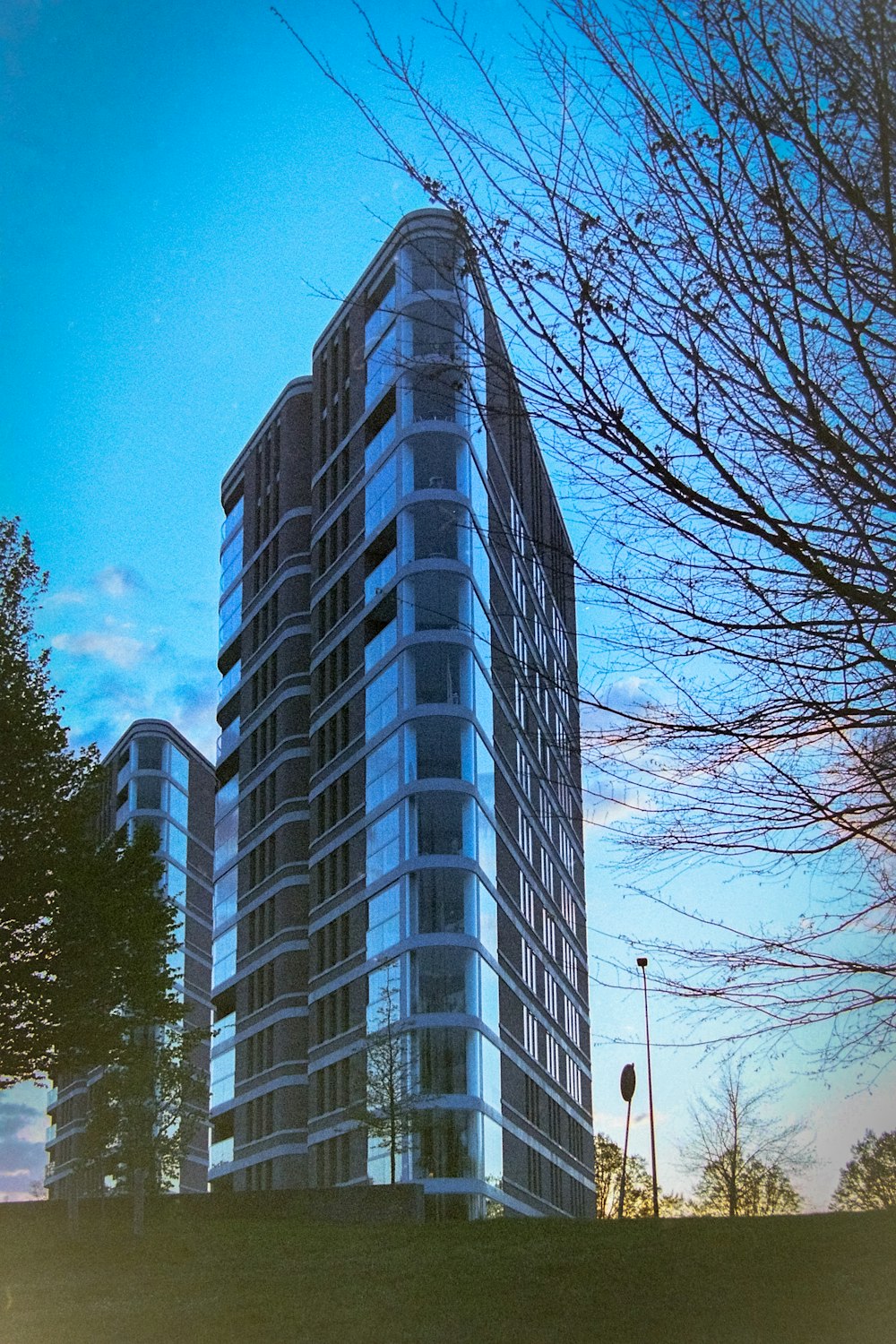 a tall building sitting next to a lush green park