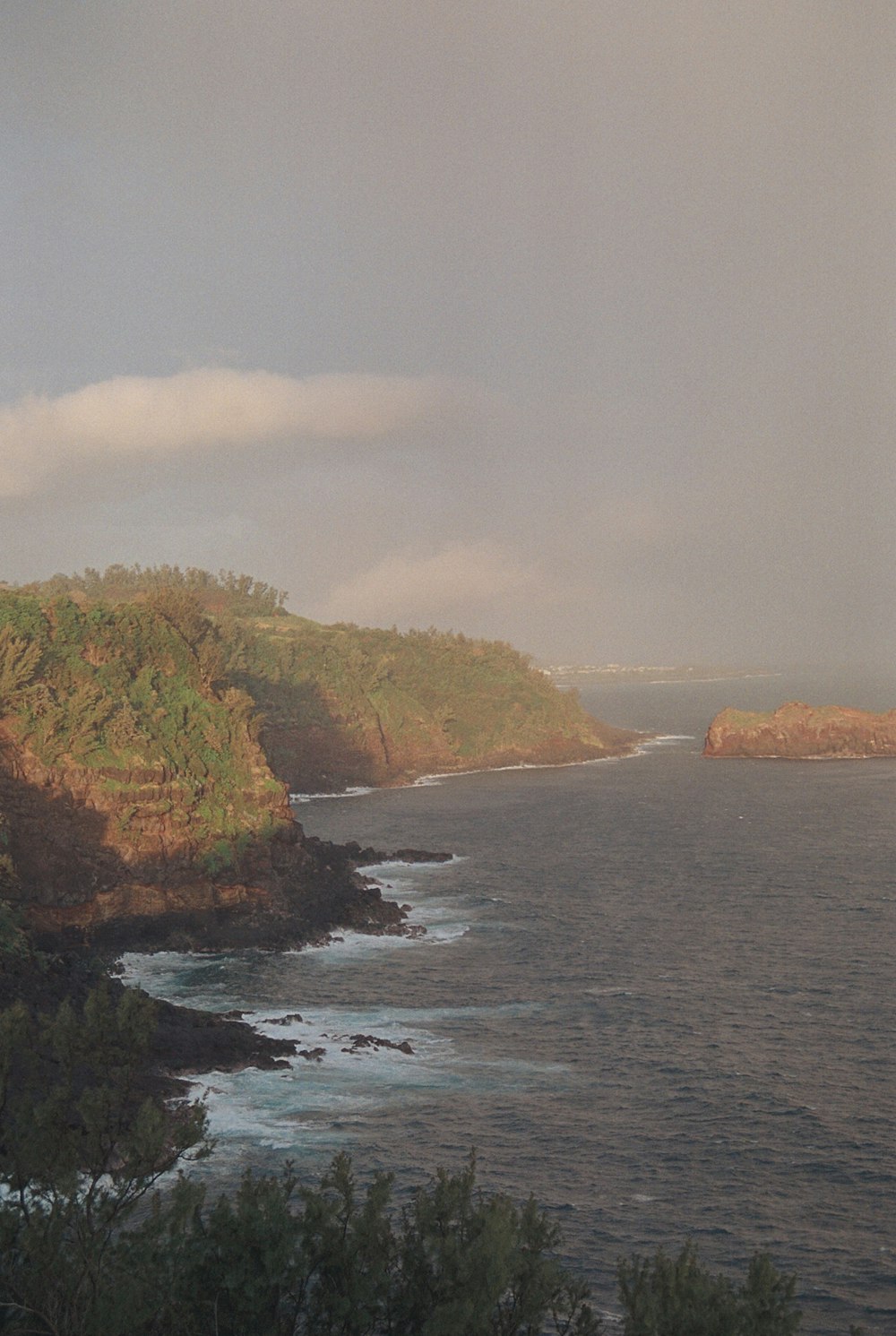 a large body of water surrounded by a lush green hillside