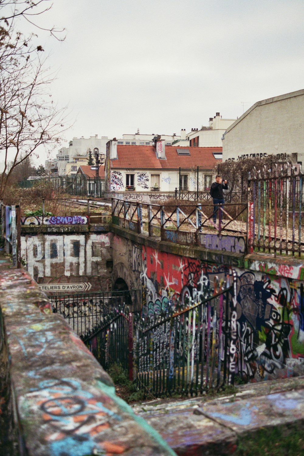 a person standing on top of a bridge covered in graffiti