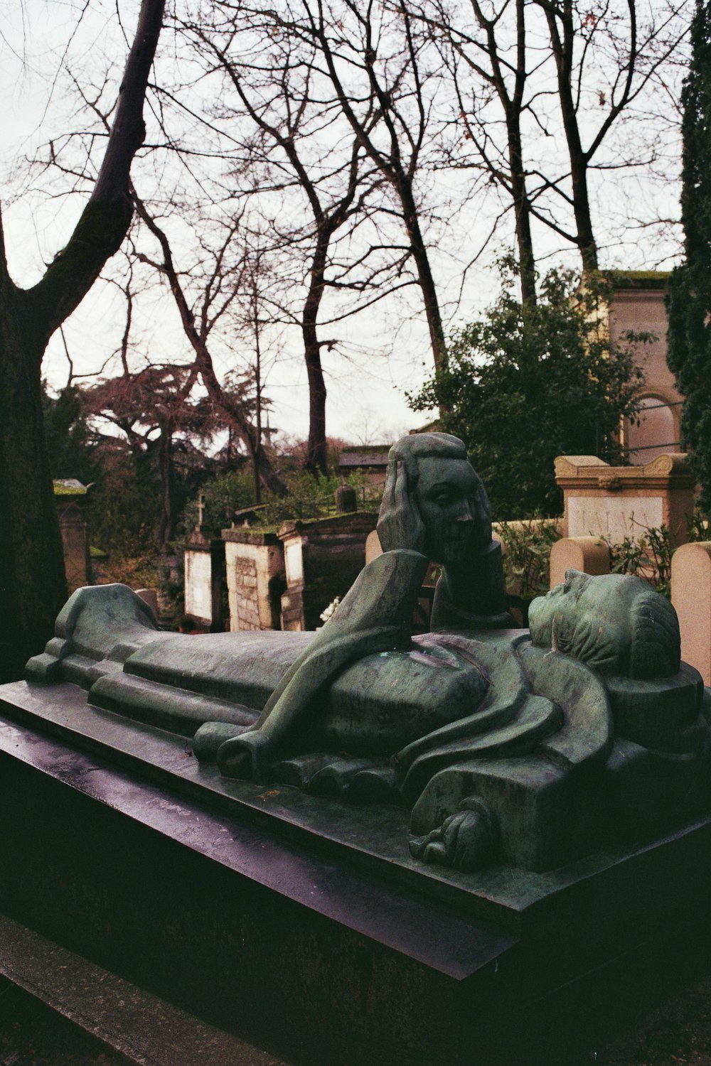 Una statua di un leone su una tomba in un cimitero
