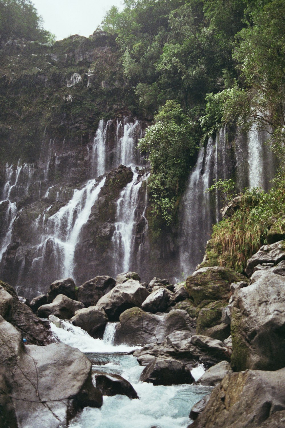 a waterfall with a bunch of rocks in front of it