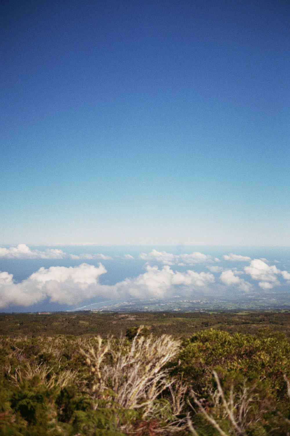 a view of the sky and clouds from the top of a hill