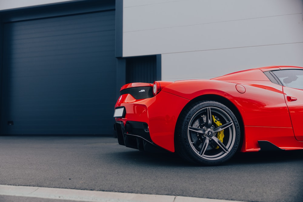 a red sports car parked in front of a garage