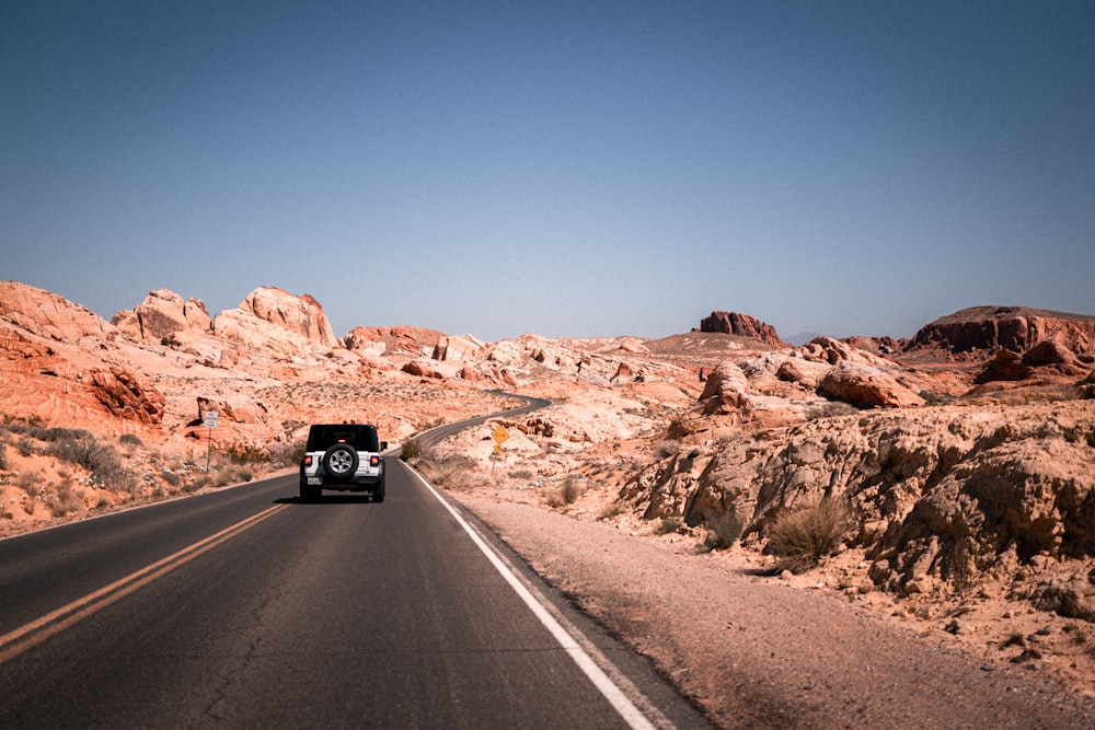 a car driving down the road in the desert