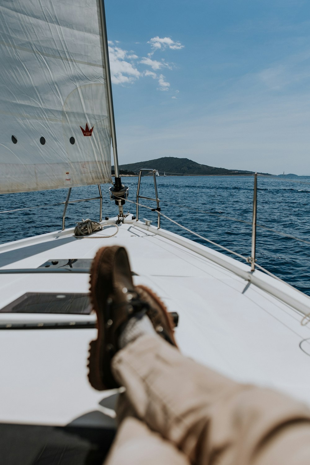 a person's feet on a sailboat in the water