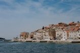 A charming coastal village with traditional Mediterranean houses under clear blue sky.