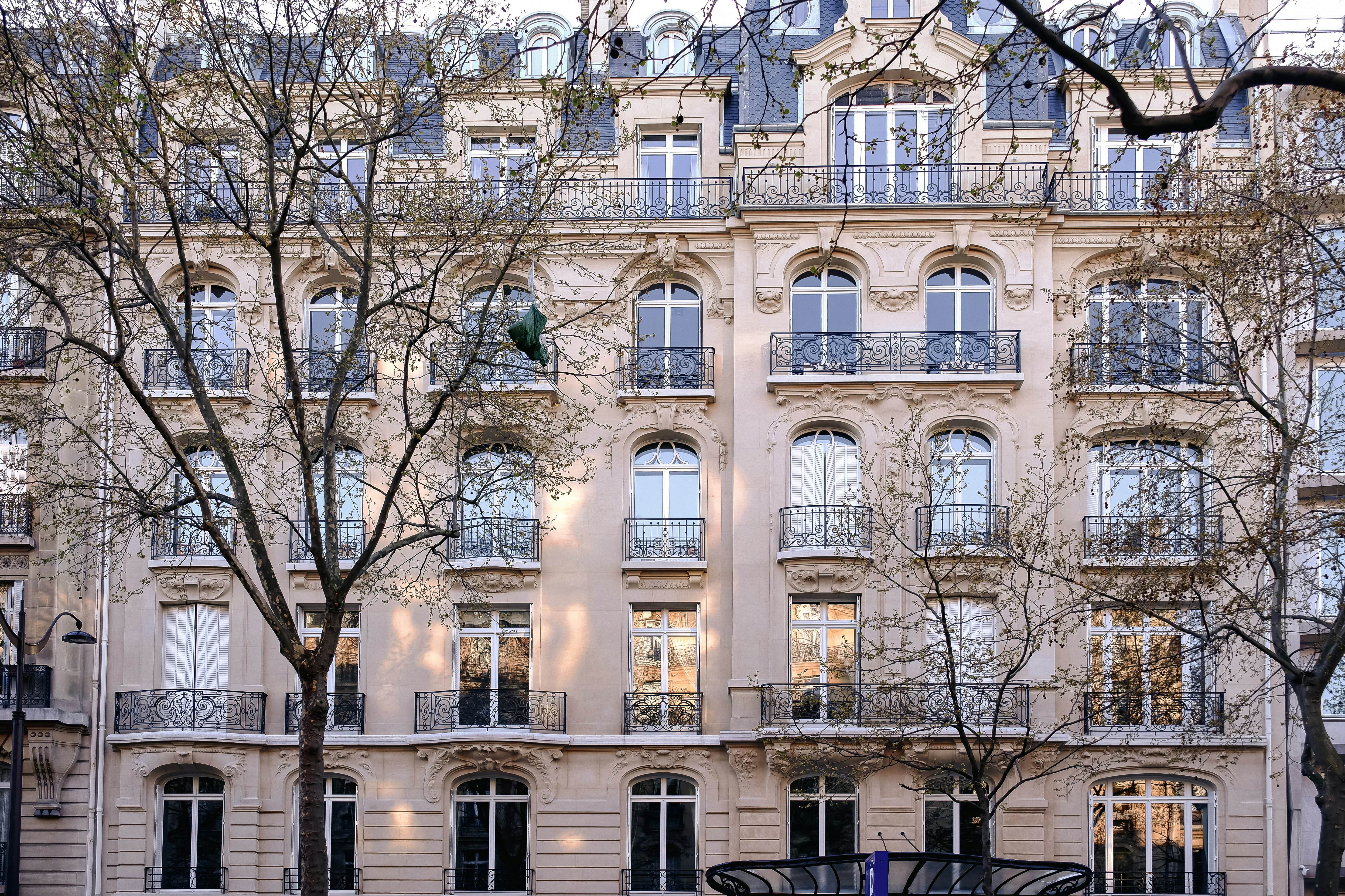 a tall beige building with large windows and balconies