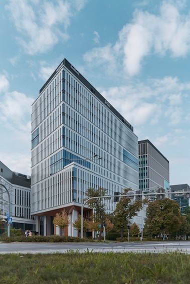 Modern office building with large glass windows and greenery outside